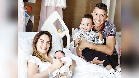 Patricia with her new born baby girl, her son and husband